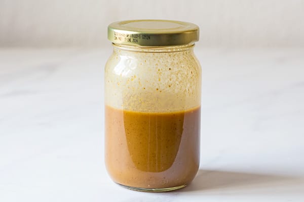 glass jar with emulsified ingredients of balsamic yogurt dressing