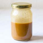 glass jar with creamy balsamic vinaigrette with golden lid