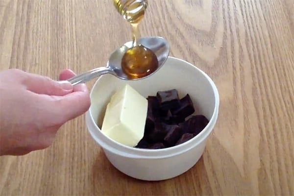 mixing chocolate, butter, honey in small white bowl