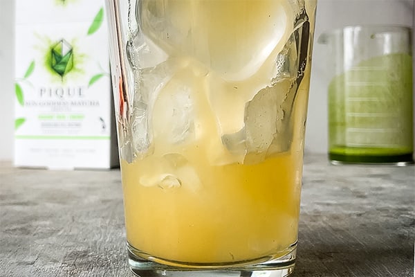apple juice being poured in a glass with ice