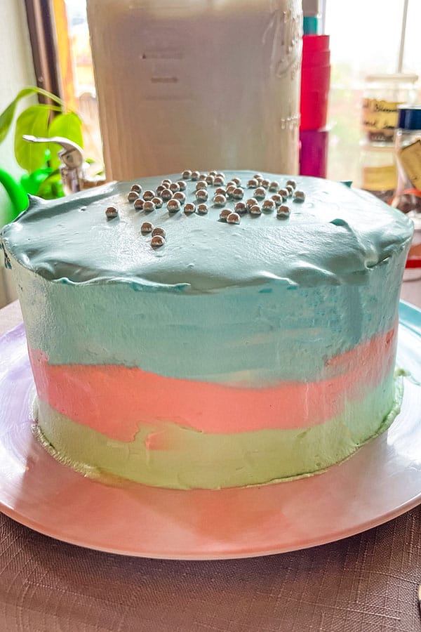 Just add magic themed birthday cake with pastel green, pink, and blue frosting