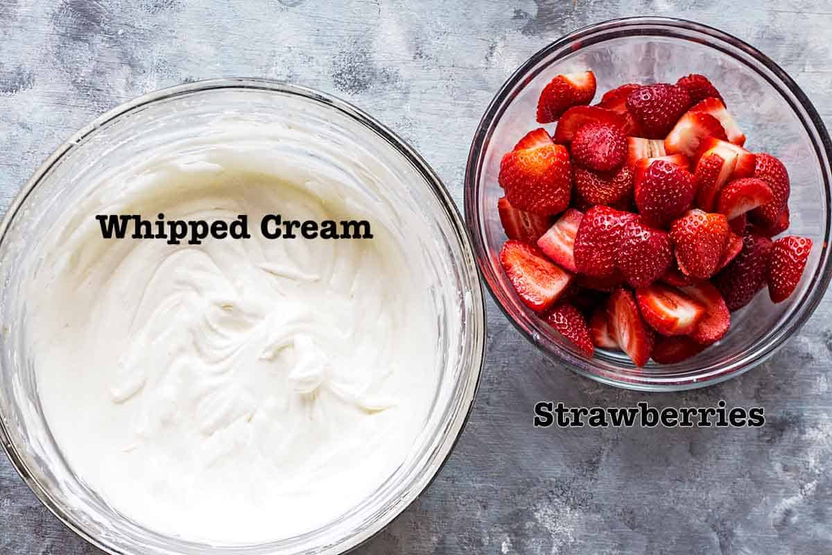 Whipped cream and strawberries in bowls 