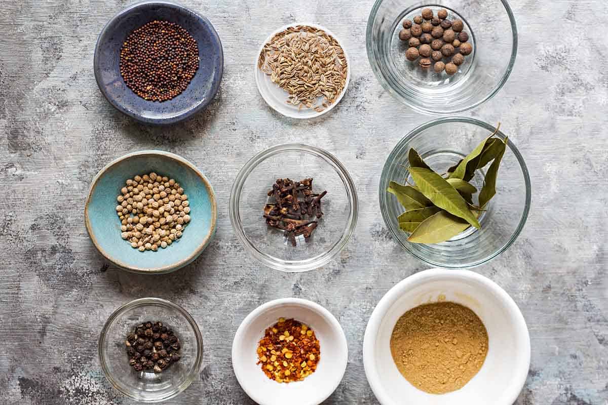 homemade pickling spice ingredients laid out in small individual bowls