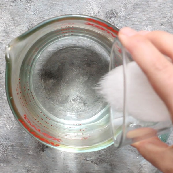 combining salt and water in measuring glass into fermenting brine