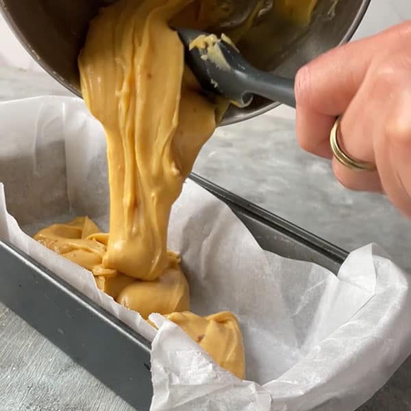 spiced pumpkin fudge pouring into lined pan