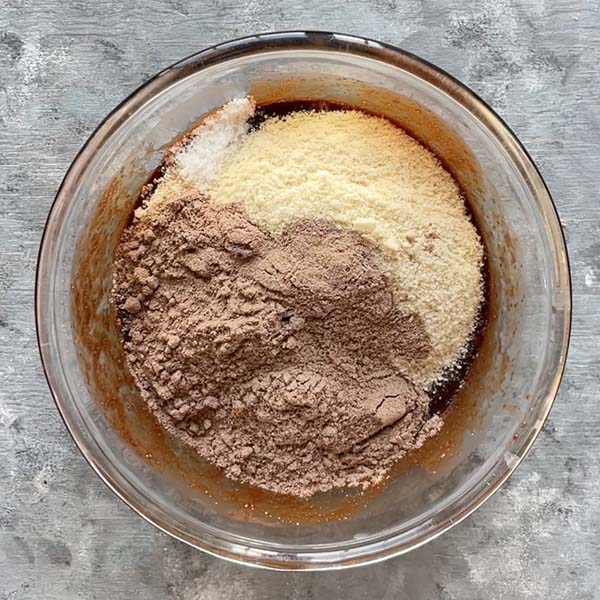 almond flour, protein powder and salt in glass bowl on top of wet ingredients