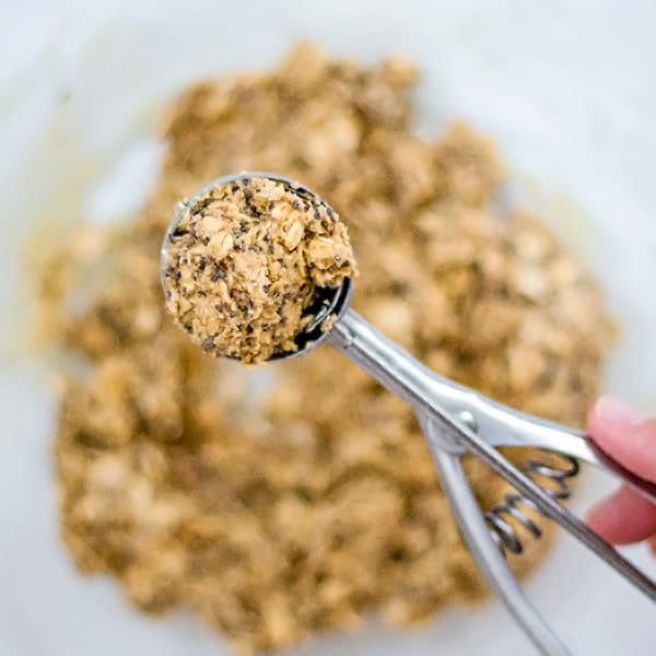 small metal cookie scoop with protein energy bites mixture