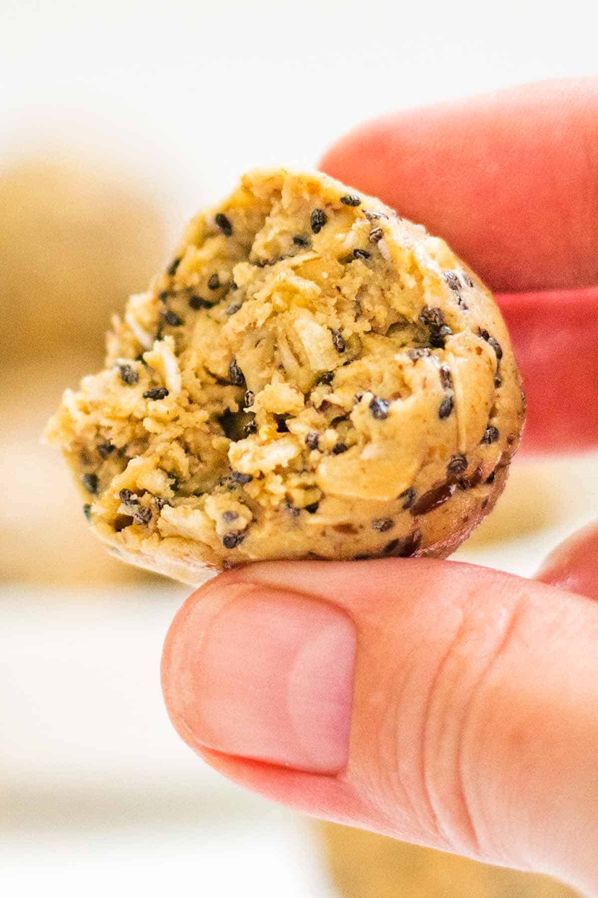 fingers holding protein ball with oatmeal