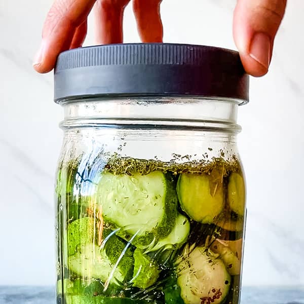 hand closing lid on pickle jar