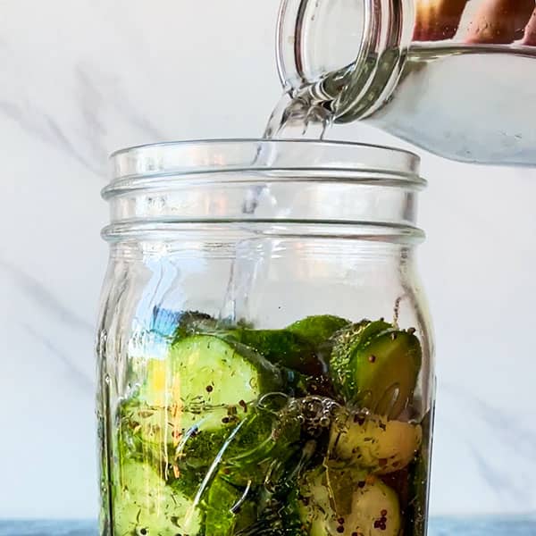 brine pouring into pickle jar