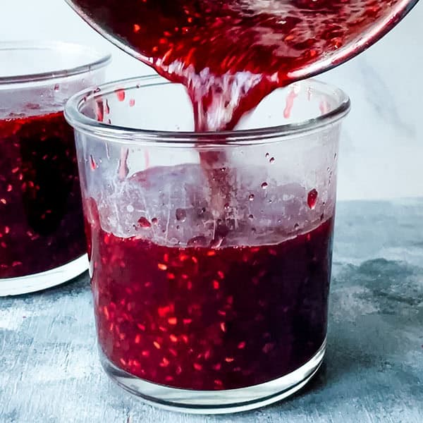 filling raspberry jam into jars