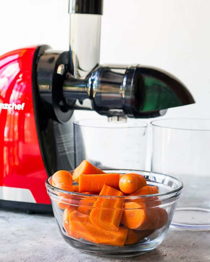 prepared carrots in bowl in front of AMZchef juicer