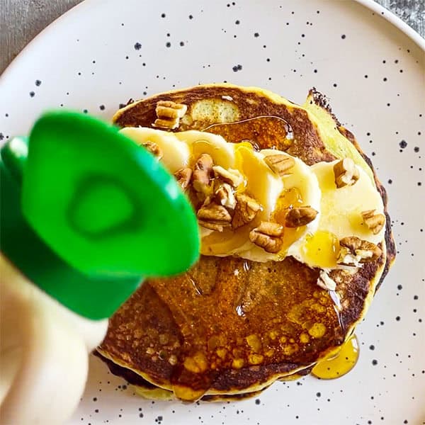 maple syrup pouring over pancakes