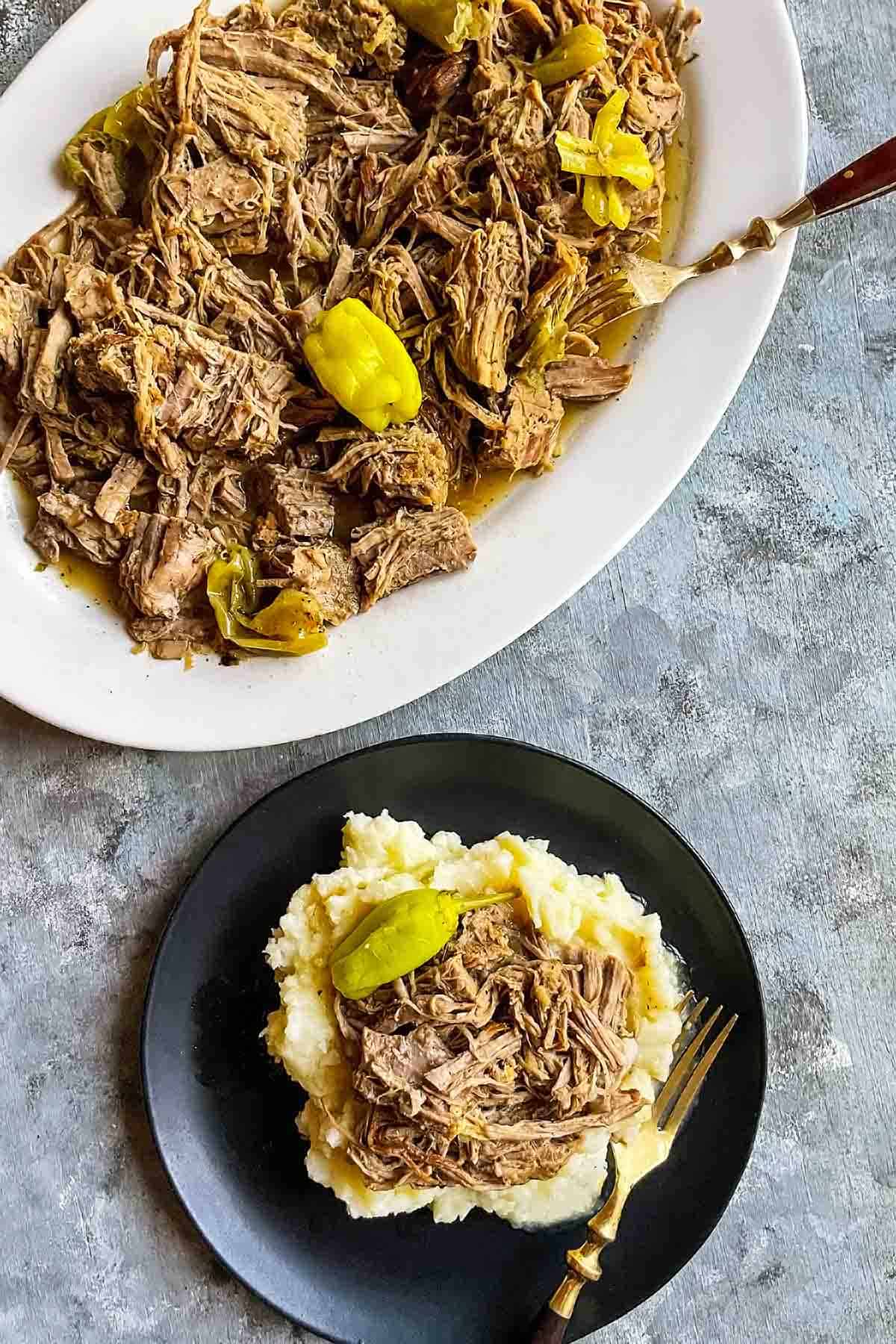 instant pot mississippi pot roast on serving platter and individual plate over mashed potatoes