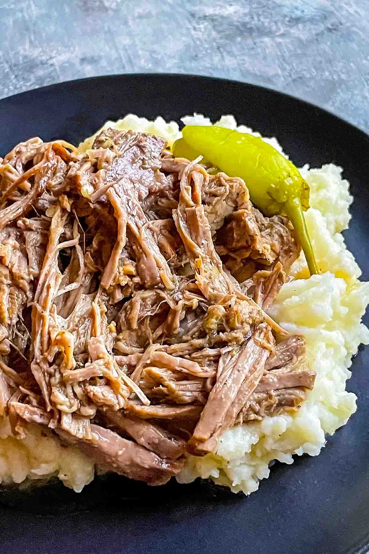 mississippi pot roast on black plate with mashed potatoes