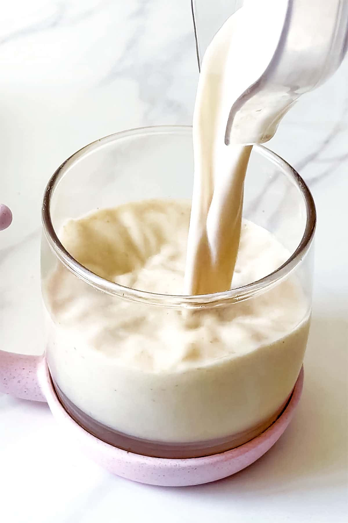 simple almond milk pouring from blender into mug