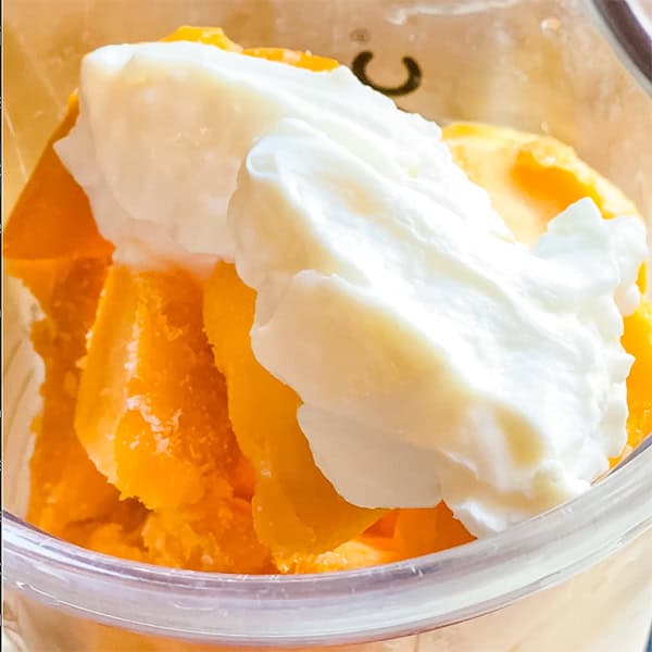 frozen mango chunks and yogurt on blender